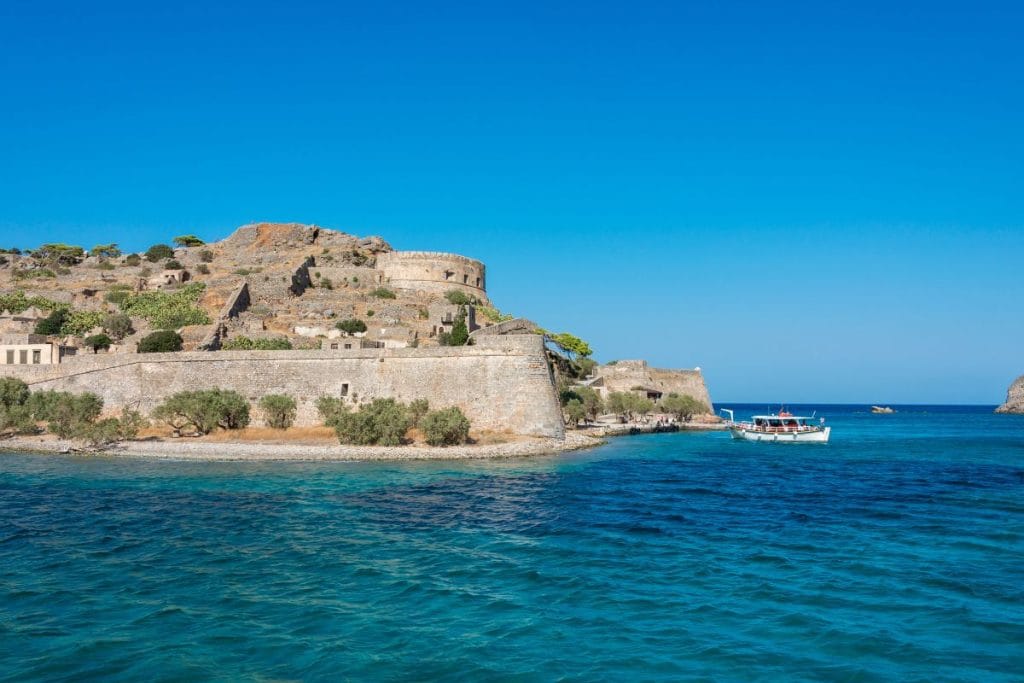 Visiting Spinalonga – fortress and boat approaching the island